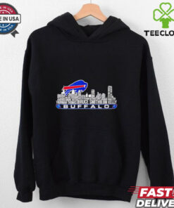 For a **Buffalo Bills shirt featuring Thurman Thomas, Bruce Smith, Jim Kelly, and a city skyline**, here's a detailed design concept: **Design Elements**: - **Central Feature**: The **Buffalo Bills logo** in the center, prominently displayed in vibrant **Buffalo blue** and **red** with a metallic shine. It can be **3D-styled** to pop against the background. - **City Skyline**: A **detailed silhouette of Buffalo city skyline** (including recognizable buildings and landmarks) should be incorporated behind the logo. The skyline should be in shades of **grey or black** to ensure the focus remains on the logo and players. Adding a subtle glow or light effect could make the skyline feel more dynamic. - **Player Images**: - **Thurman Thomas**, **Bruce Smith**, and **Jim Kelly** should be included in **action poses**, either in a **side-by-side layout** or in a **triangular formation**. They should have a slightly **retro-style treatment**, capturing their iconic moments. Use an **artistic illustration** style rather than direct photos to keep the design cohesive and unique. - Each player’s **name and number** should be placed underneath their image (e.g., **Thurman Thomas #34**, **Bruce Smith #78**, **Jim Kelly #12**) in bold, **athletic-style font**. - **Text Elements**: - Across the top or bottom of the design, include the text **