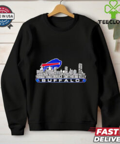 For a **Buffalo Bills shirt featuring Thurman Thomas, Bruce Smith, Jim Kelly, and a city skyline**, here's a detailed design concept: **Design Elements**: - **Central Feature**: The **Buffalo Bills logo** in the center, prominently displayed in vibrant **Buffalo blue** and **red** with a metallic shine. It can be **3D-styled** to pop against the background. - **City Skyline**: A **detailed silhouette of Buffalo city skyline** (including recognizable buildings and landmarks) should be incorporated behind the logo. The skyline should be in shades of **grey or black** to ensure the focus remains on the logo and players. Adding a subtle glow or light effect could make the skyline feel more dynamic. - **Player Images**: - **Thurman Thomas**, **Bruce Smith**, and **Jim Kelly** should be included in **action poses**, either in a **side-by-side layout** or in a **triangular formation**. They should have a slightly **retro-style treatment**, capturing their iconic moments. Use an **artistic illustration** style rather than direct photos to keep the design cohesive and unique. - Each player’s **name and number** should be placed underneath their image (e.g., **Thurman Thomas #34**, **Bruce Smith #78**, **Jim Kelly #12**) in bold, **athletic-style font**. - **Text Elements**: - Across the top or bottom of the design, include the text **