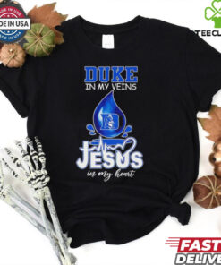 Duke Blue Devils in My Veins, Jesus in My Heart Shirt featuring a powerful design that combines school pride with faith. Show your devotion to both the Duke Blue Devils and your spiritual beliefs with this unique, meaningful apparel.