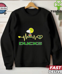Oregon Ducks x Snoopy Player Heartbeat Shirt, featuring a unique design that combines the Oregon Ducks logo and mascot with Snoopy in a fun, heartwarming graphic. Perfect for fans who love both the Ducks and the iconic Peanuts character, celebrating their passion for the team with a playful twist.