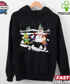Snoopy Christmas Snowman Shirt featuring a cheerful design of Snoopy and Woodstock building or posing with a snowman, capturing the festive spirit of the holiday season.