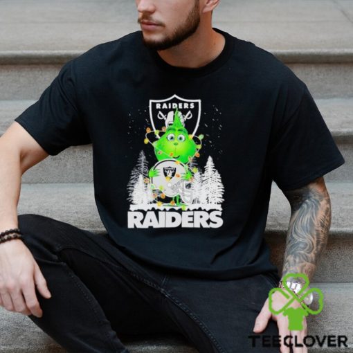 The Baby Grinch hugging Las Vegas Raiders helmet snowy forest Christmas hoodie, sweater, longsleeve, shirt v-neck, t-shirt