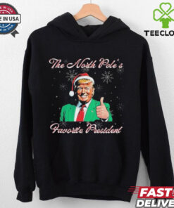 Trump The North Pole’s Favorite President Christmas T-shirts featuring a festive design with a humorous take on Donald Trump as the North Pole's favorite president, adding a holiday twist.