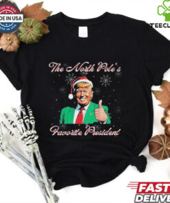 Trump The North Pole’s Favorite President Christmas T-shirts featuring a festive design with a humorous take on Donald Trump as the North Pole's favorite president, adding a holiday twist.