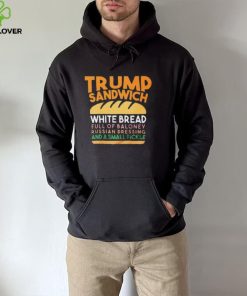 Trunp sandwich white bread full of bakone y russian dressing and a small picke shirt